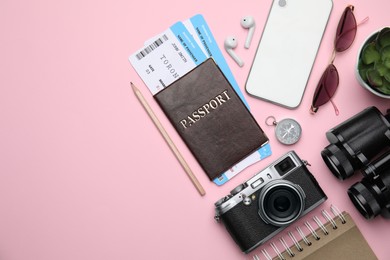 Flat lay composition with passport, tickets and travel items on pink background. Space for text