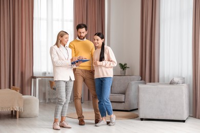 Photo of Real estate agent working with couple in new apartment