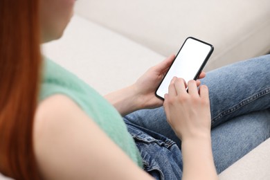 Photo of Woman using mobile phone indoors, closeup view