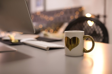 Stylish workplace with modern computer on desk. Focus on cup of drink