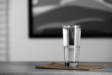 Photo of Glass of pure water on grey table indoors, space for text