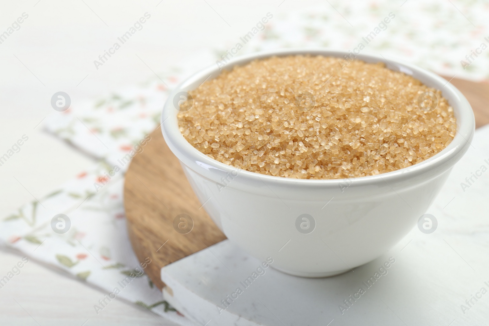 Photo of Brown sugar in bowl on table, closeup. Space for text