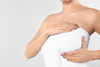 Woman checking her breast on white background, closeup