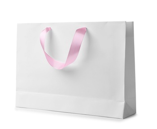 Photo of Paper shopping bag with ribbon handles on white background. Mockup for design