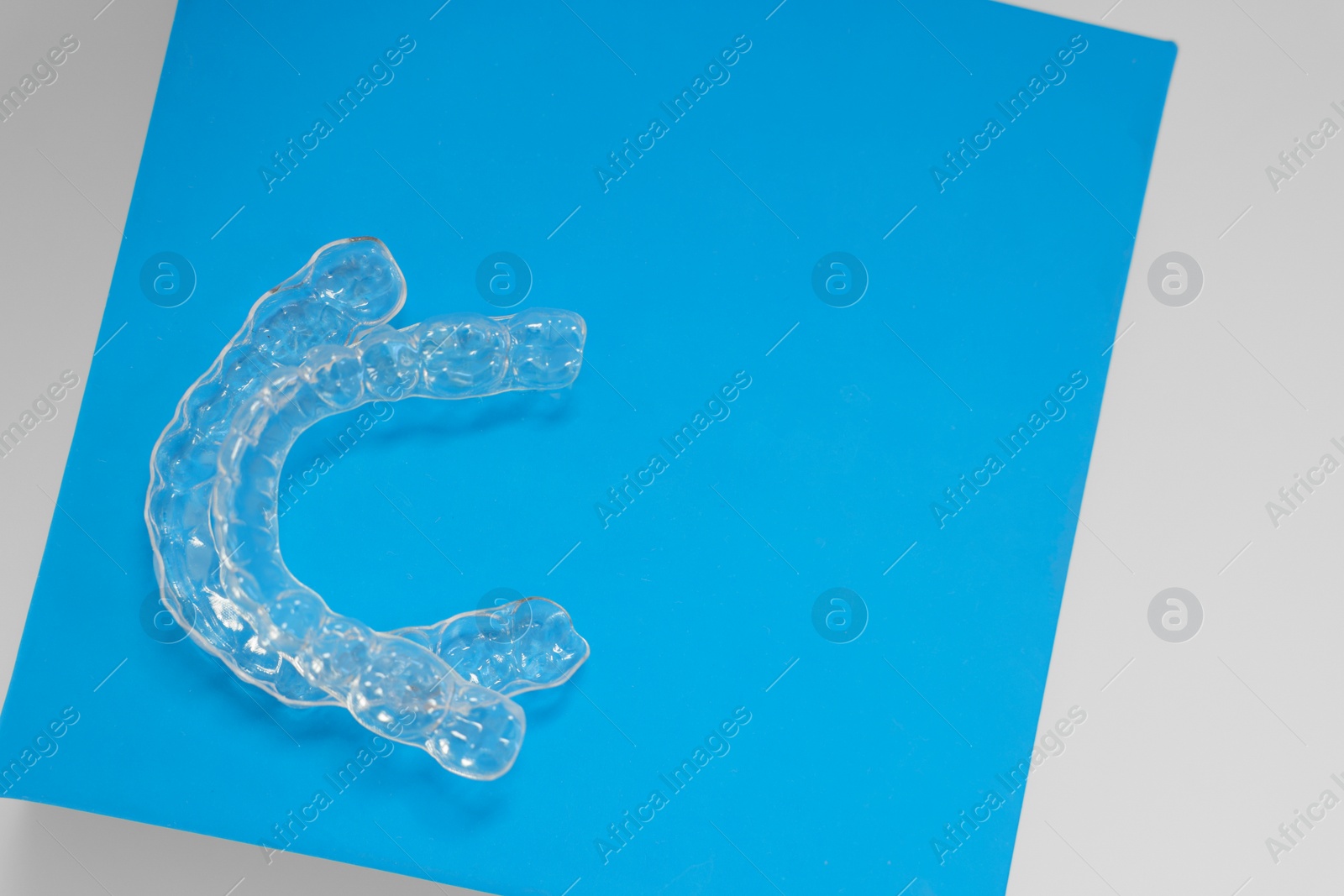 Photo of Transparent dental aligners on color background, flat lay. Space for text