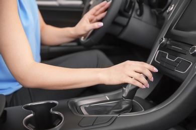 Young woman sitting in driver's seat of car, closeup