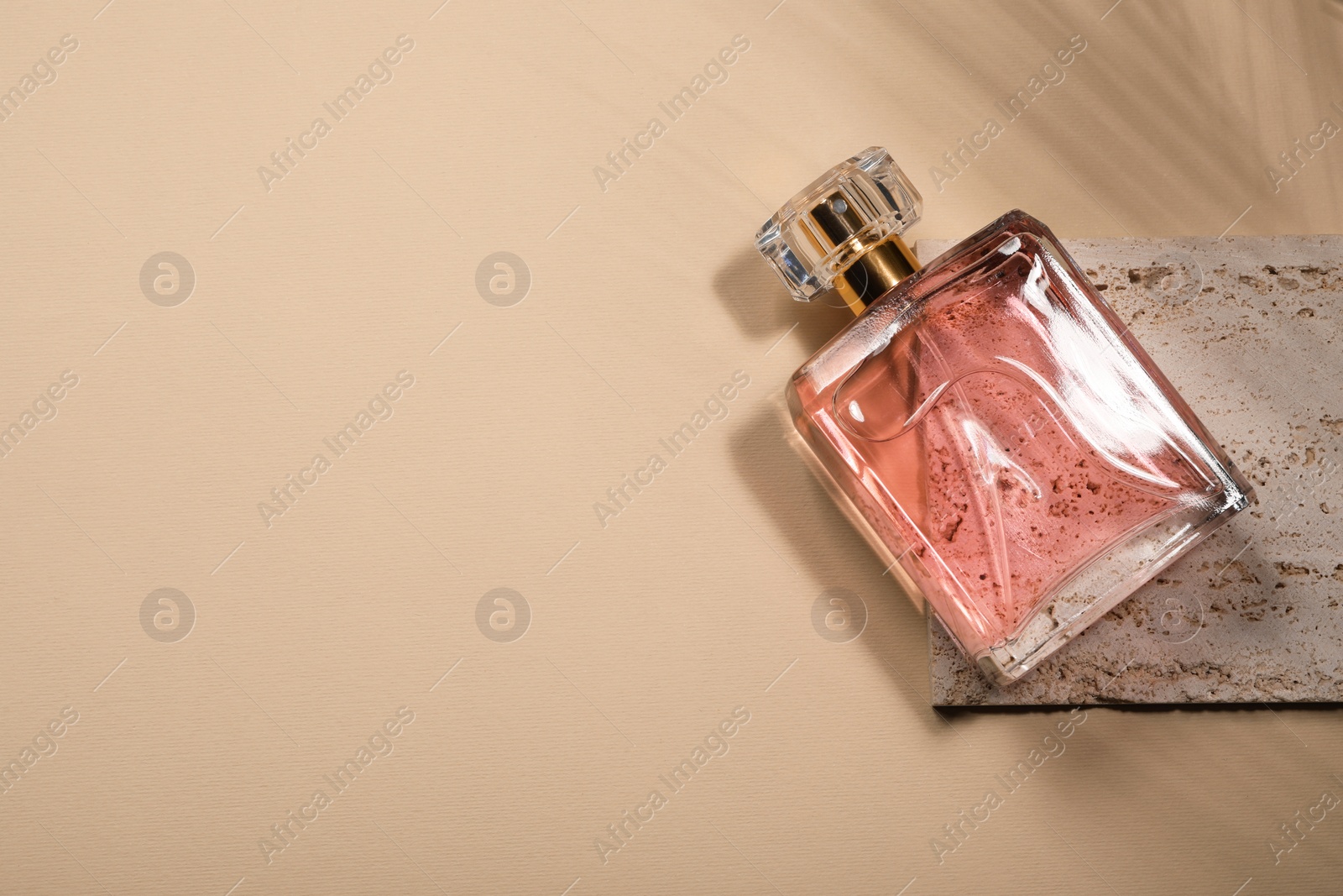 Photo of Luxury women's perfume in bottle on beige background, top view. Space for text