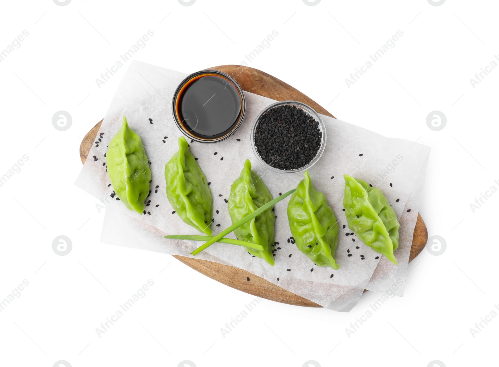 Photo of Delicious green dumplings (gyozas), soy sauce and sesame seeds isolated on white, top view