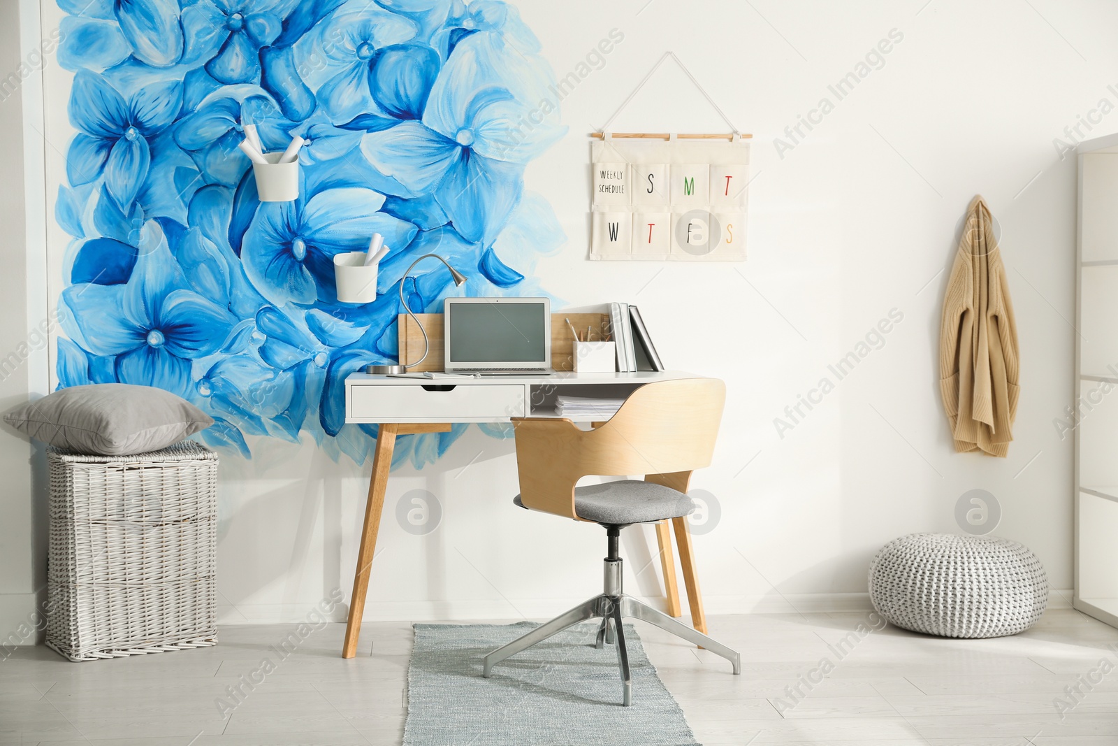 Photo of Stylish living room interior with blue flowers painted on wall. Floral pattern