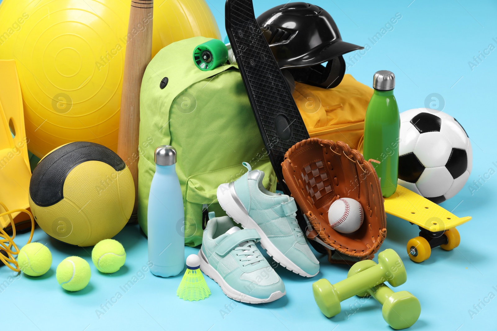 Photo of Many different sports equipment on light blue background, closeup