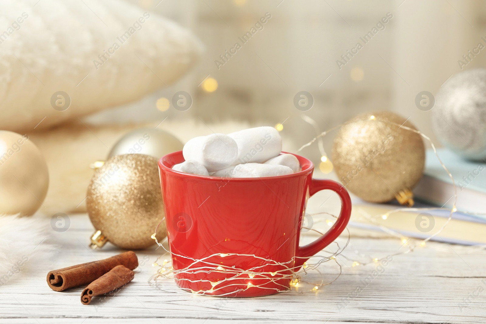 Photo of Composition with cup of hot winter drink and Christmas lights on table. Cozy season