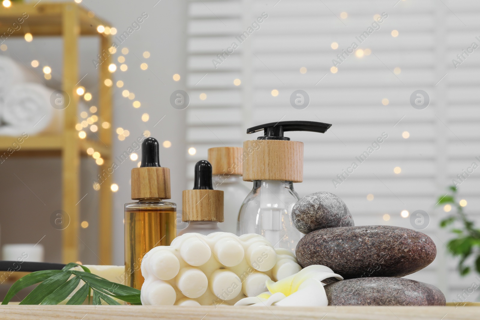 Photo of Composition with different spa products and plumeria flower on tray in bathroom