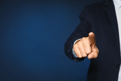 Photo of Businessman pointing on color background, closeup view of hand with space for text
