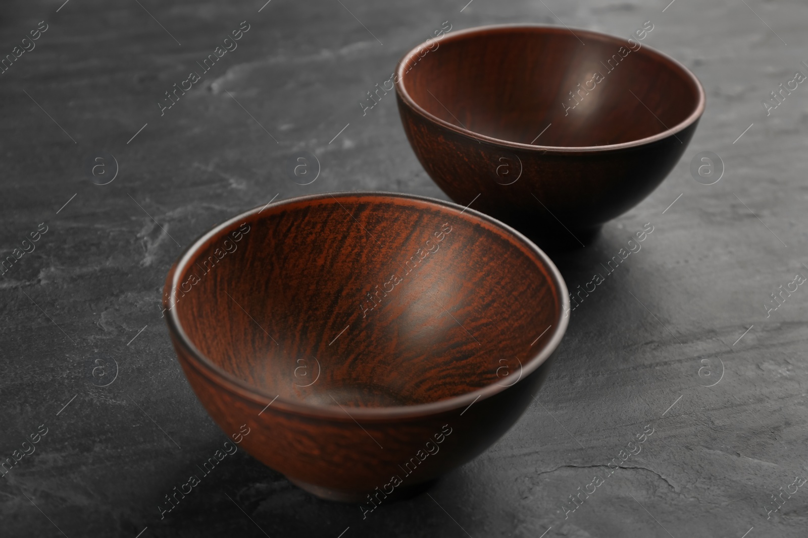 Photo of Beautiful empty clay bowls on black table