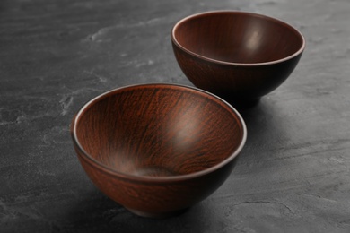 Photo of Beautiful empty clay bowls on black table