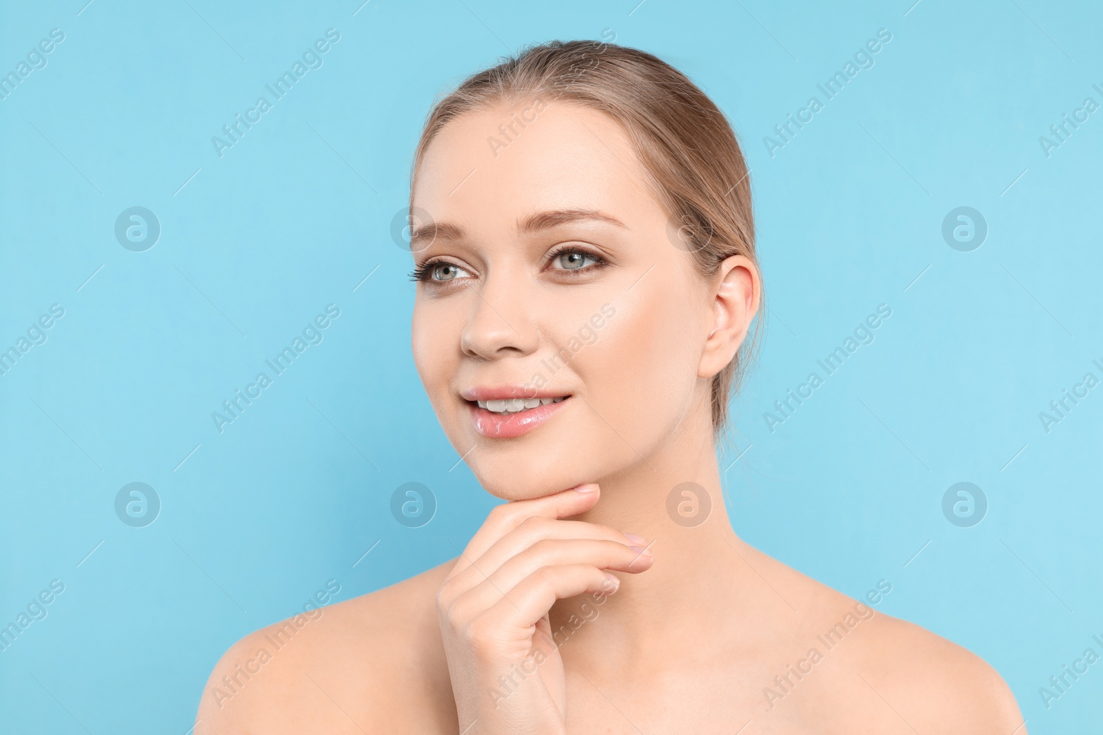 Photo of Portrait of young woman with beautiful face on blue background