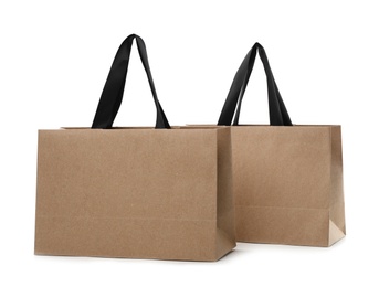 Photo of Paper shopping bags with handles on white background. Mockup for design