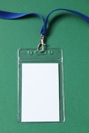 Photo of Blank badge with string on green background, top view