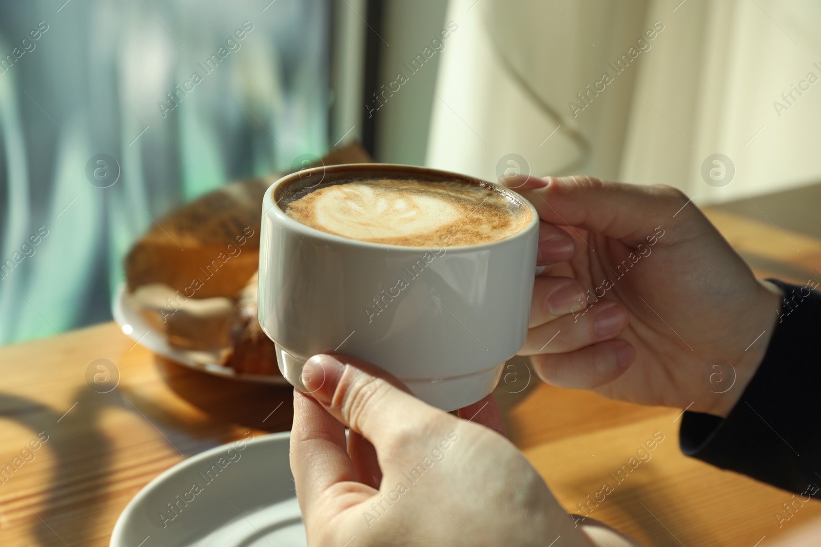 Photo of Woman with cup of fresh aromatic coffee at table in cafe