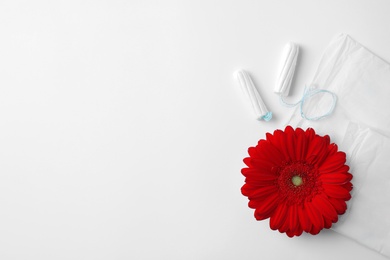 Different feminine hygiene products and flower on white background, top view with space for text. Gynecological care