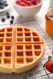 Photo of Tasty Belgian waffle with strawberry on table, closeup