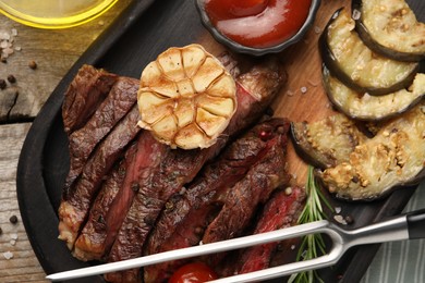 Photo of Delicious grilled beef with vegetables, tomato sauce and spices on table, top view