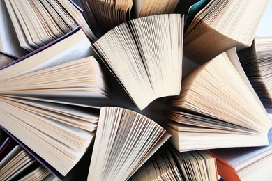 Photo of Collection of different books on white shelf, above view