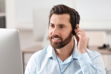 Photo of Hotline operator with headset working in office, space for text