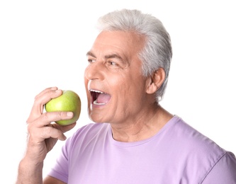 Photo of Mature man with healthy teeth and apple on white background