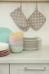 Photo of Clean plates and bowls on white marble countertop in kitchen