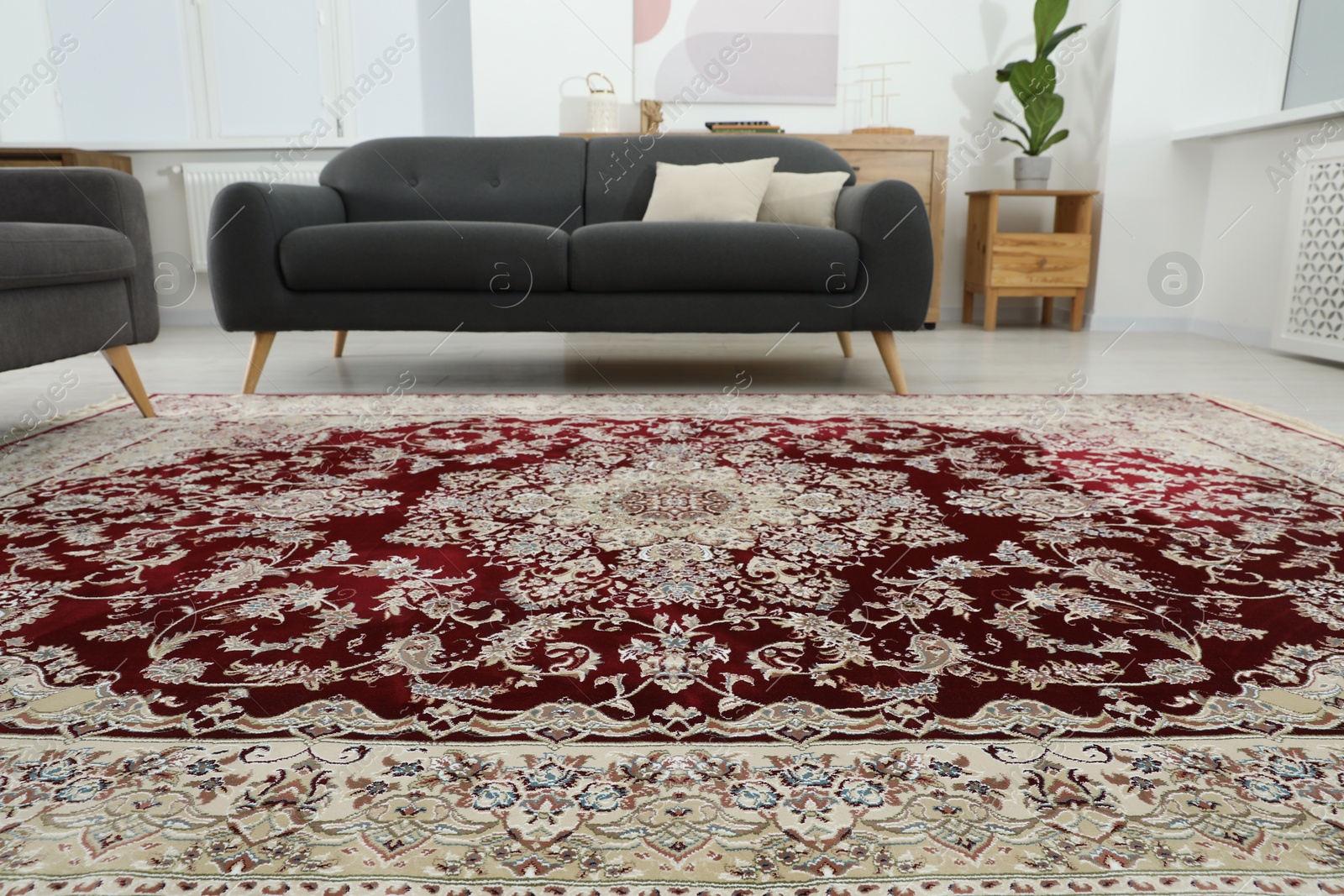 Photo of Cozy room interior with stylish furniture and soft carpet with beautiful pattern