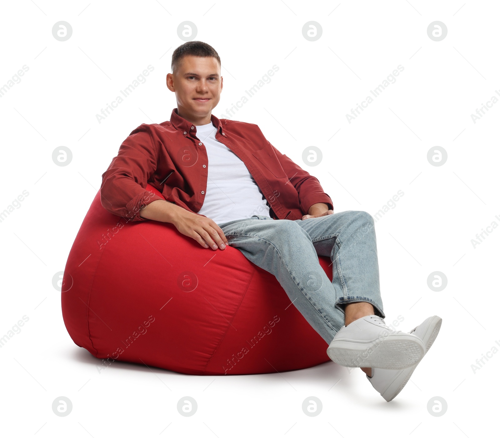 Photo of Handsome man sitting on red bean bag chair against white background