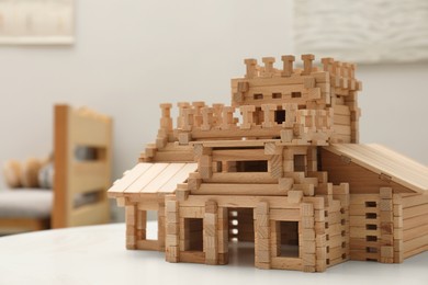 Wooden castle on white table indoors, space for text. Children's toy