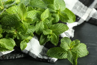 Fresh green mint leaves on black table, closeup