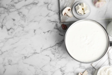 Photo of Delicious creamy sauce in pan on marble table, flat lay. Space for text
