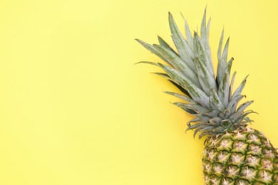 Photo of Delicious ripe pineapple on yellow background, top view. Space for text