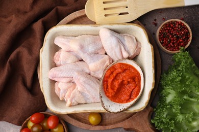 Photo of Flat lay composition with marinade, raw chicken and other products on table