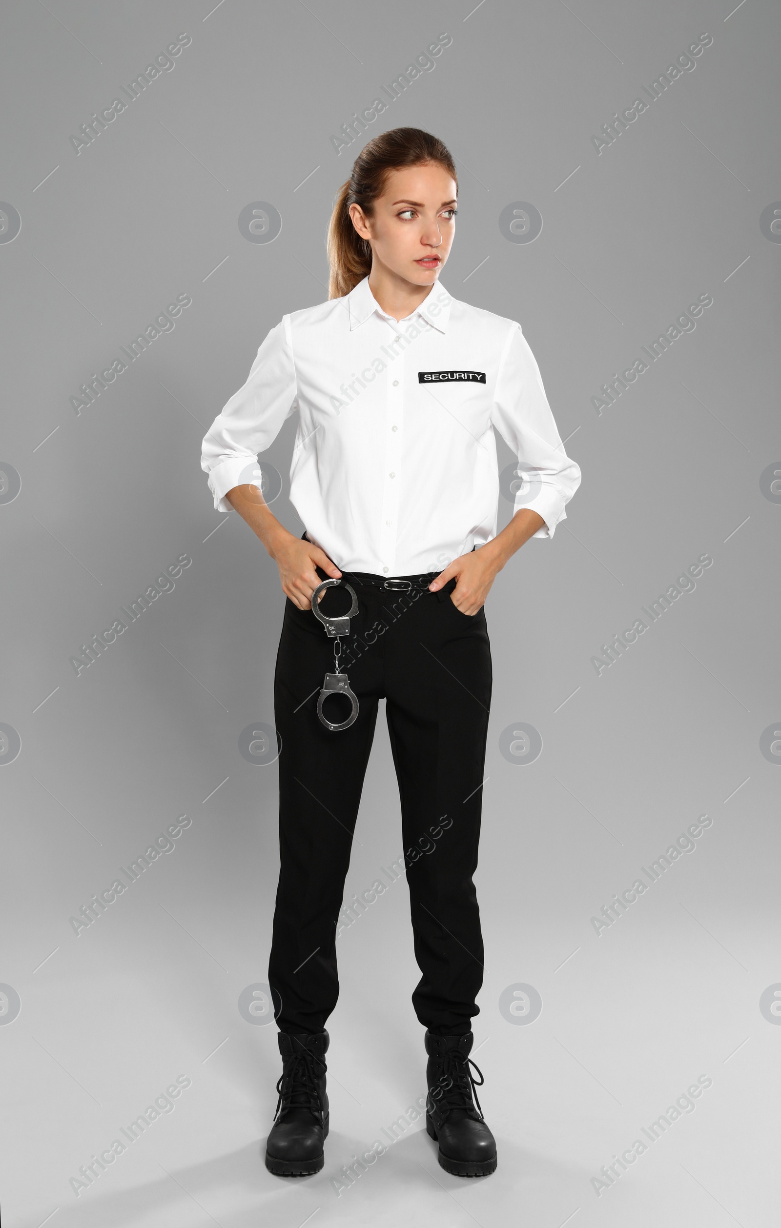 Photo of Female security guard in uniform on grey background