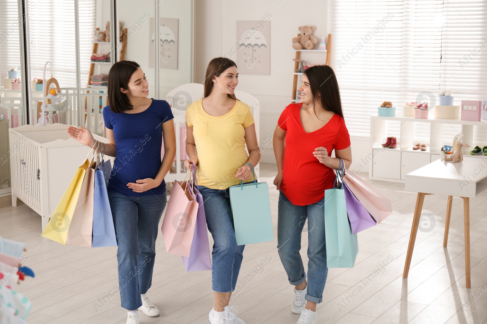 Photo of Happy pregnant women with shopping bags in store