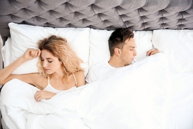 Lovely young couple sleeping in bed at home