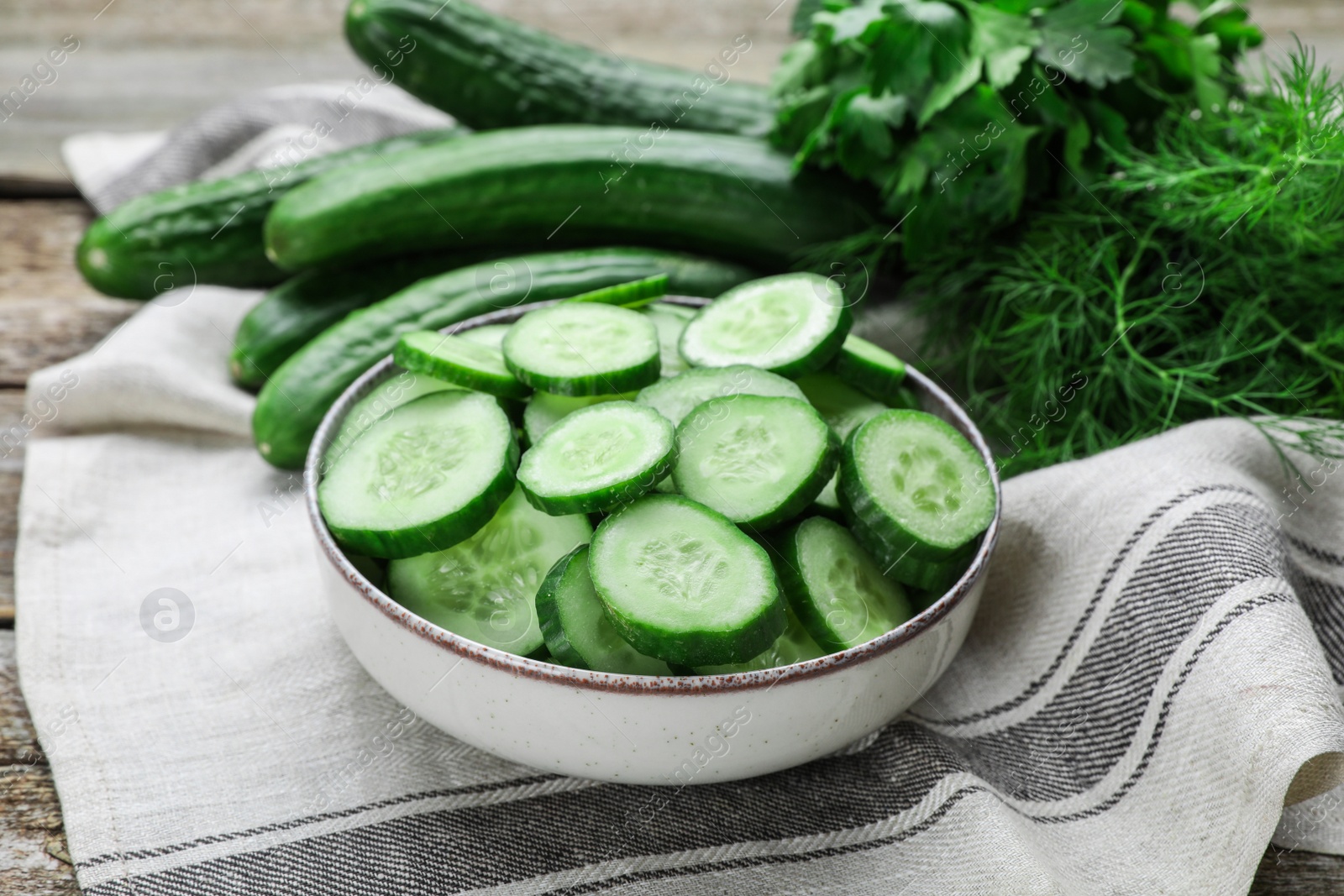 Photo of Fresh ripe cucumbers and greens on table, closeup