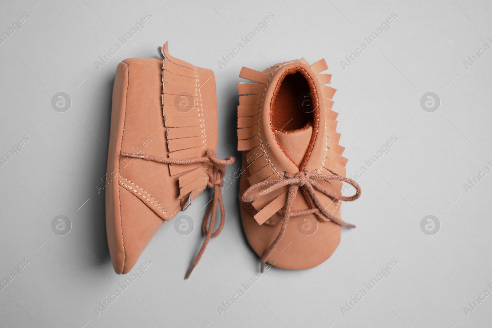 Photo of Cute baby shoes on grey background, flat lay
