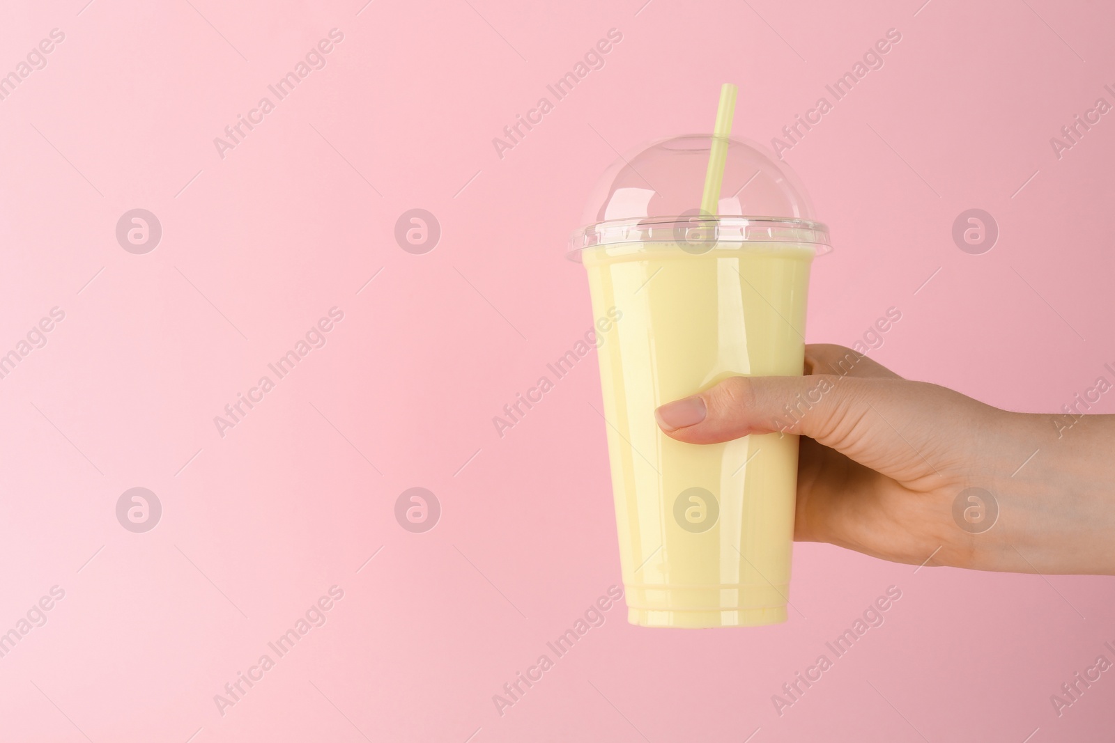 Photo of Woman with plastic cup of tasty smoothie on pink background, closeup. Space for text