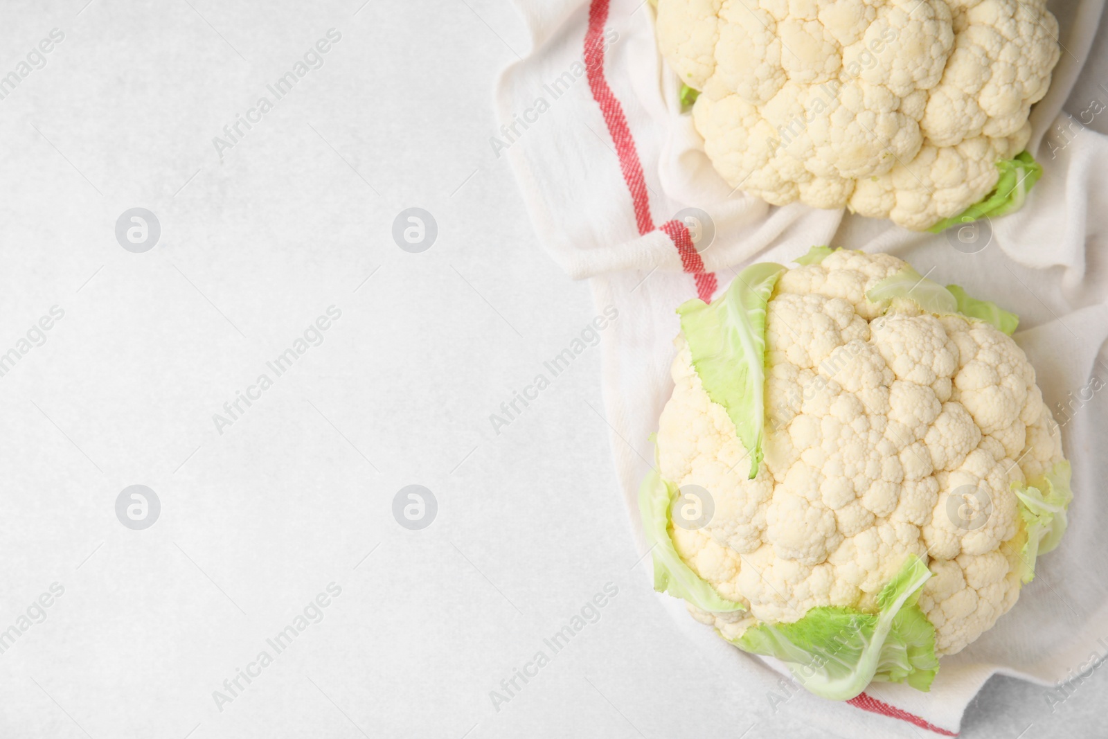 Photo of Whole fresh raw cauliflowers on white table, flat lay. Space for text