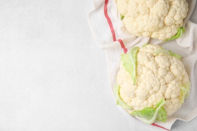 Whole fresh raw cauliflowers on white table, flat lay. Space for text