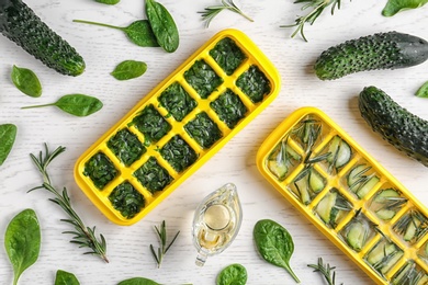 Photo of Flat lay composition with ice cube trays and herbs on white wooden background