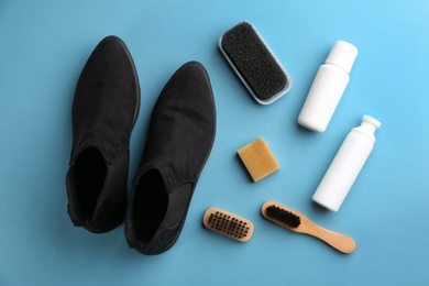 Photo of Stylish footwear with shoe care accessories on light blue background, flat lay