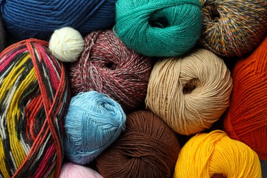 Photo of Different balls of woolen knitting yarns as background, top view