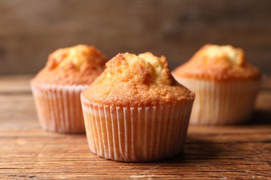 Photo of Delicious sweet muffins on wooden table, closeup