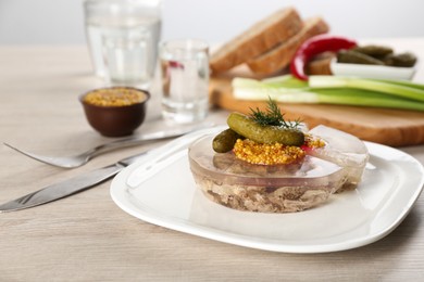 Delicious aspic with meat and vegetables served on light wooden table